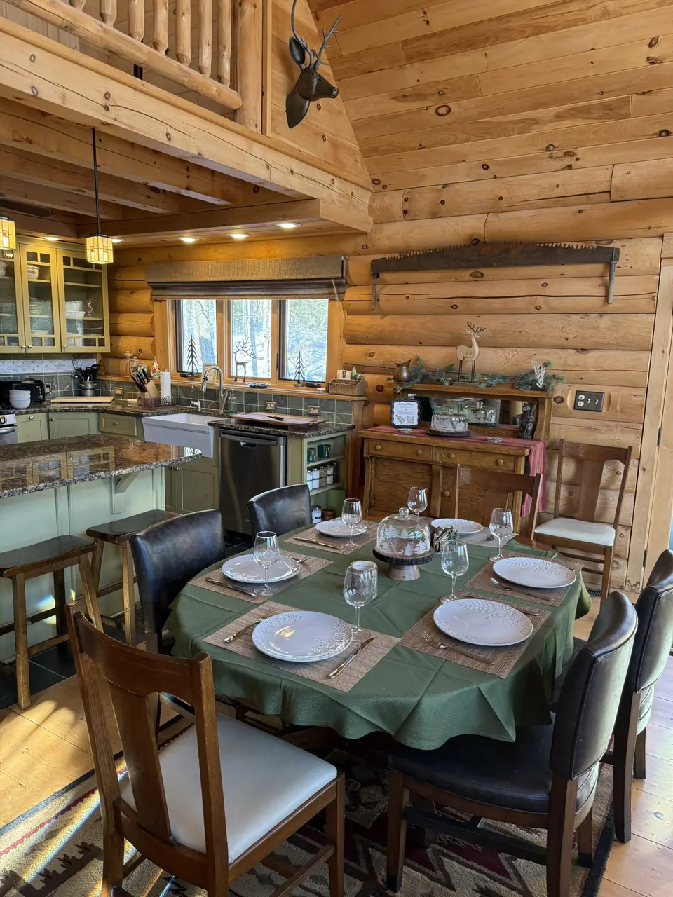 Round dining table set for a meal beside the log walls