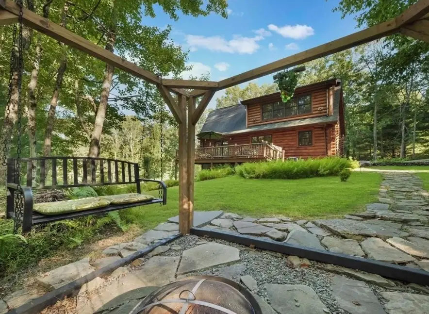 View from the fire pit pergola toward the cabin across the lawn