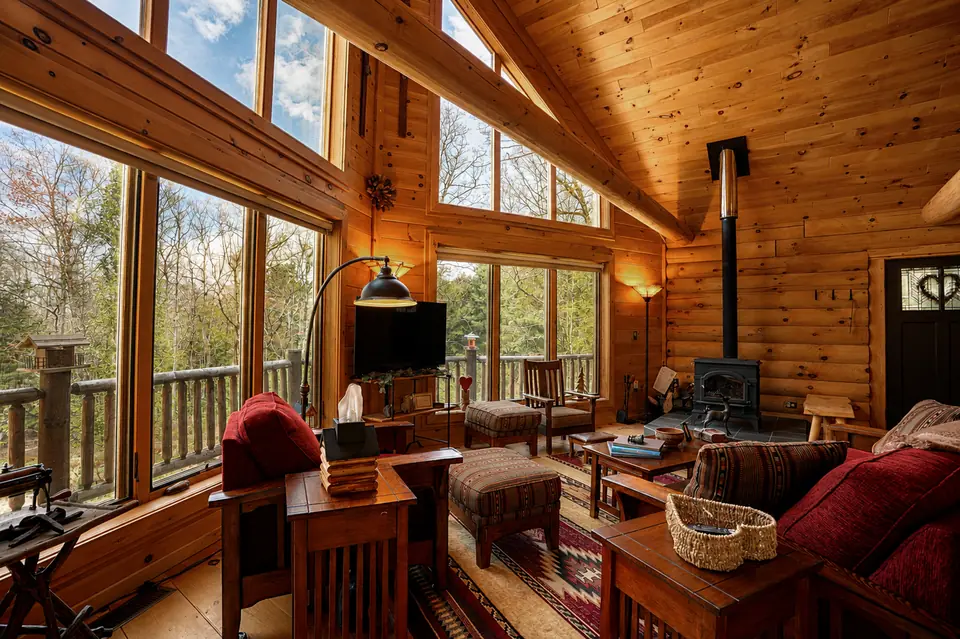 Living room seating with forest views through floor to ceiling windows