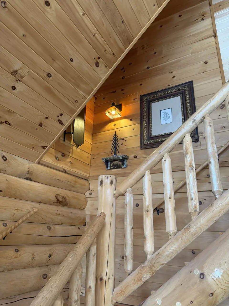 Log staircase with railings leading up to the loft