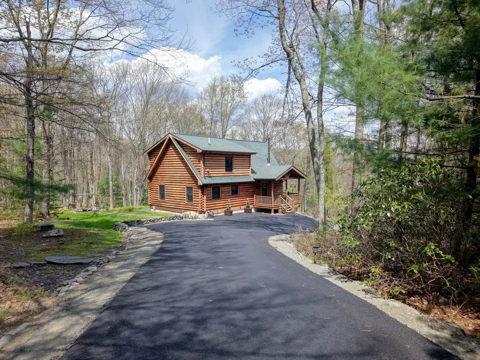 Paved driveway leading through the spring woods to the cabin